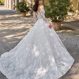 Elegant off-shoulder lace wedding gown with long sleeves and dramatic cathedral train in Italian courtyard — Sima Couture | Endless UAE