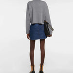 Gray wool-blend cropped sweater shown from back, styled with blue patterned mini skirt and black leather bag — Loewe | Endless UAE