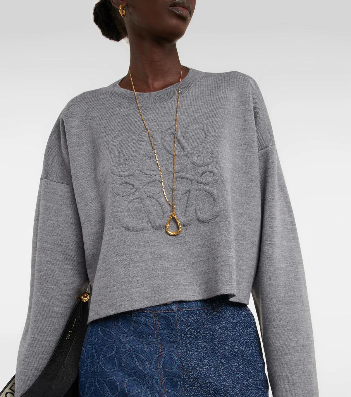 Gray wool-blend cropped sweater with embossed Anagram logo, styled with gold necklace and blue jeans — Loewe | Endless UAE