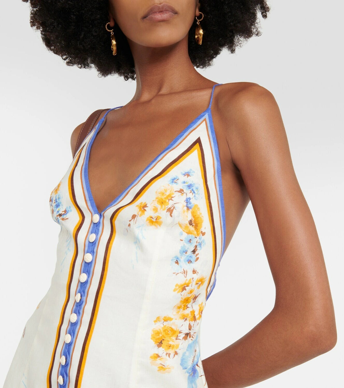 Woman wearing a floral printed white linen midi dress with blue and yellow trim — Zimmerman | Endless UAE