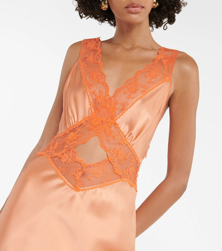 Woman wearing Aries Cut Out Gown in orange peach with lace details and gold sandals — Sir The Label | Endless UAE