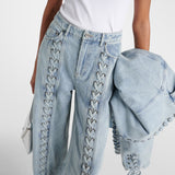 Light blue straight-leg jeans with decorative lace-up detailing along the front seams, paired with matching denim jacket — Rotate | Endless UAE