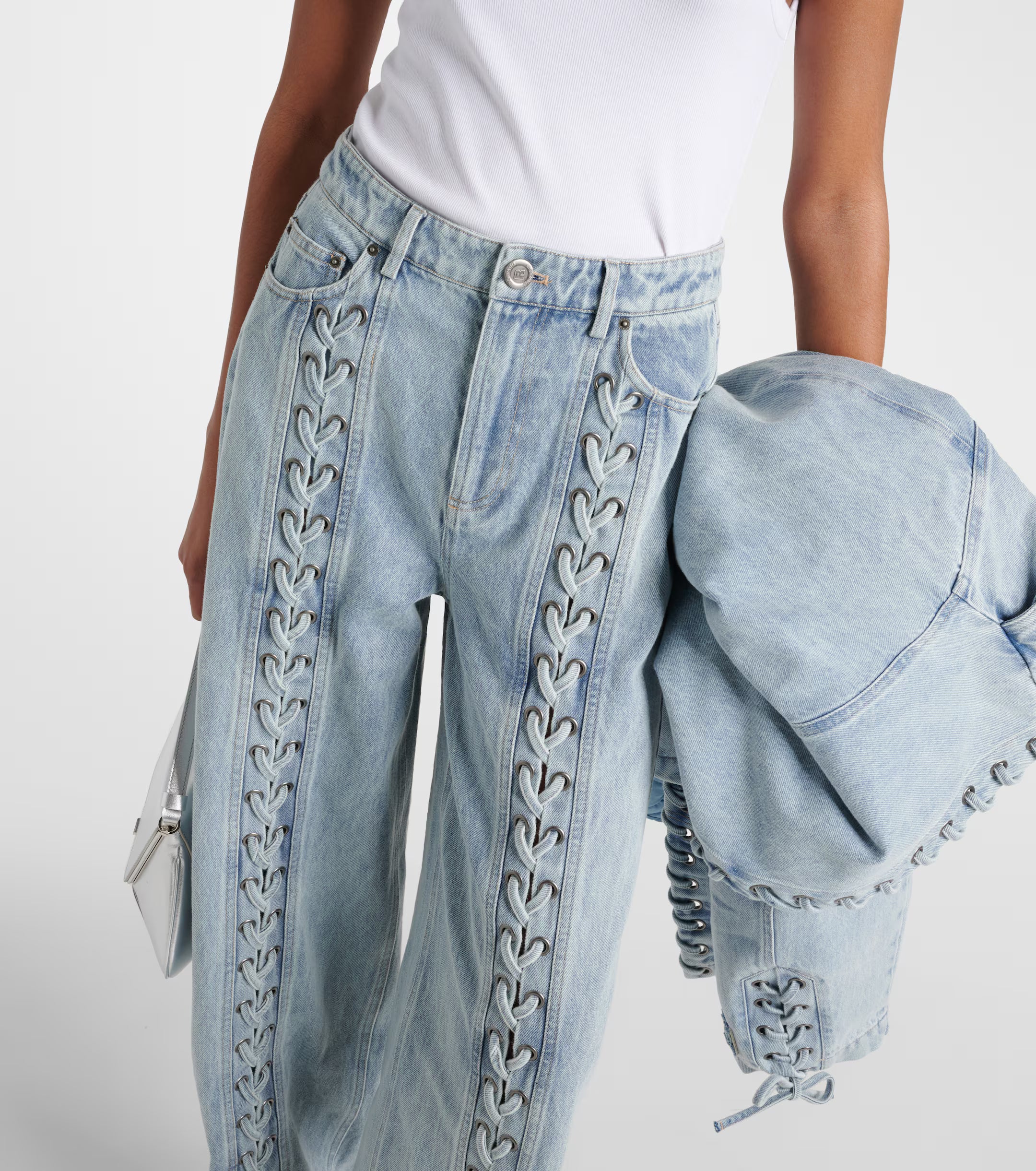 Light blue straight-leg jeans with decorative lace-up detailing along the front seams, paired with matching denim jacket — Rotate | Endless UAE