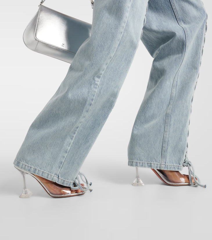 Light blue straight-leg jeans with lace-up side details and ankle ties, styled with clear heels and silver bag — Rotate | Endless UAE
