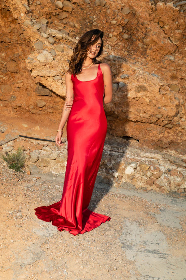 Woman wearing red sleeveless maxi dress against rustic stone wall — By Keara | Endless UAE