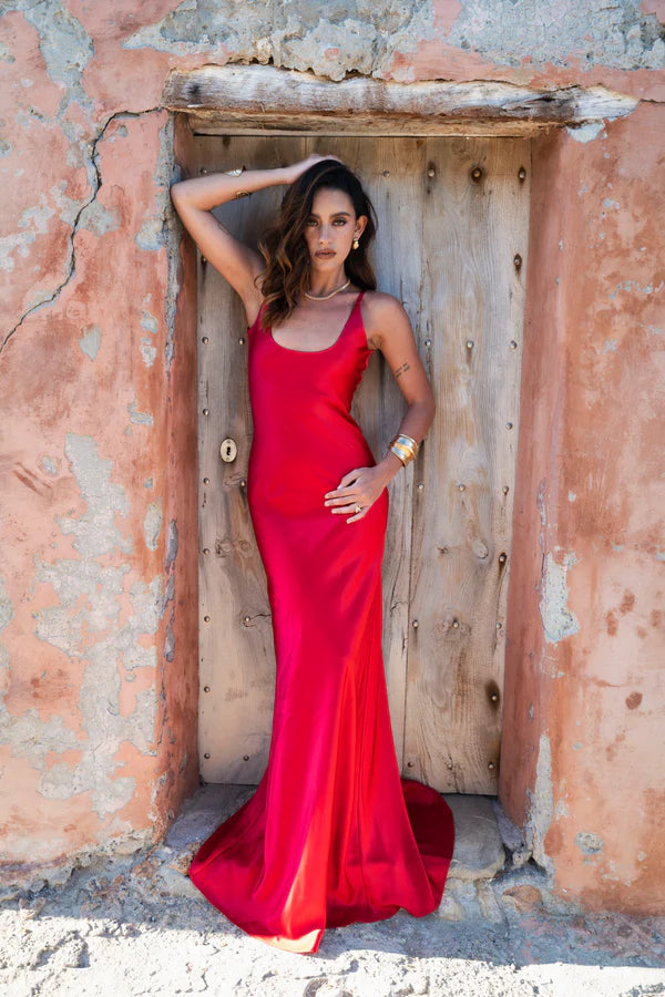Woman wearing red sleeveless maxi dress against rustic stone wall — By Keara | Endless UAE