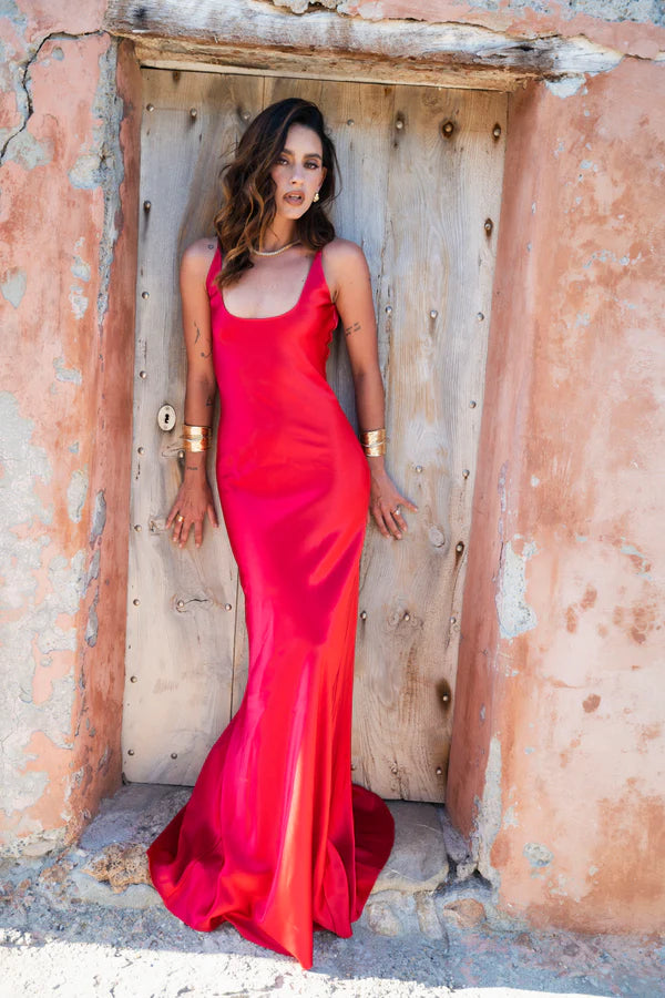 Woman wearing red sleeveless maxi dress against rustic stone wall — By Keara | Endless UAE
