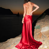 Elegant red satin backless evening gown with flowing train at sunset beach — By Keara | Endless UAE