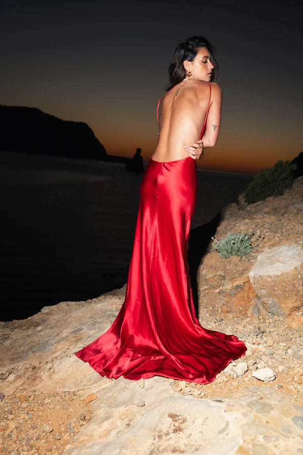 Elegant red satin backless maxi dress with cowl back and flowing train at sunset — By Keara | Endless UAE
