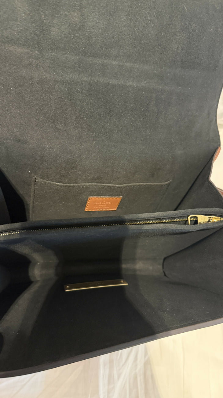 Black leather handbag interior showing grey suede lining, inner pocket with tan label, gold zipper, and metal pen — Louis Vuitton | Endless UAE