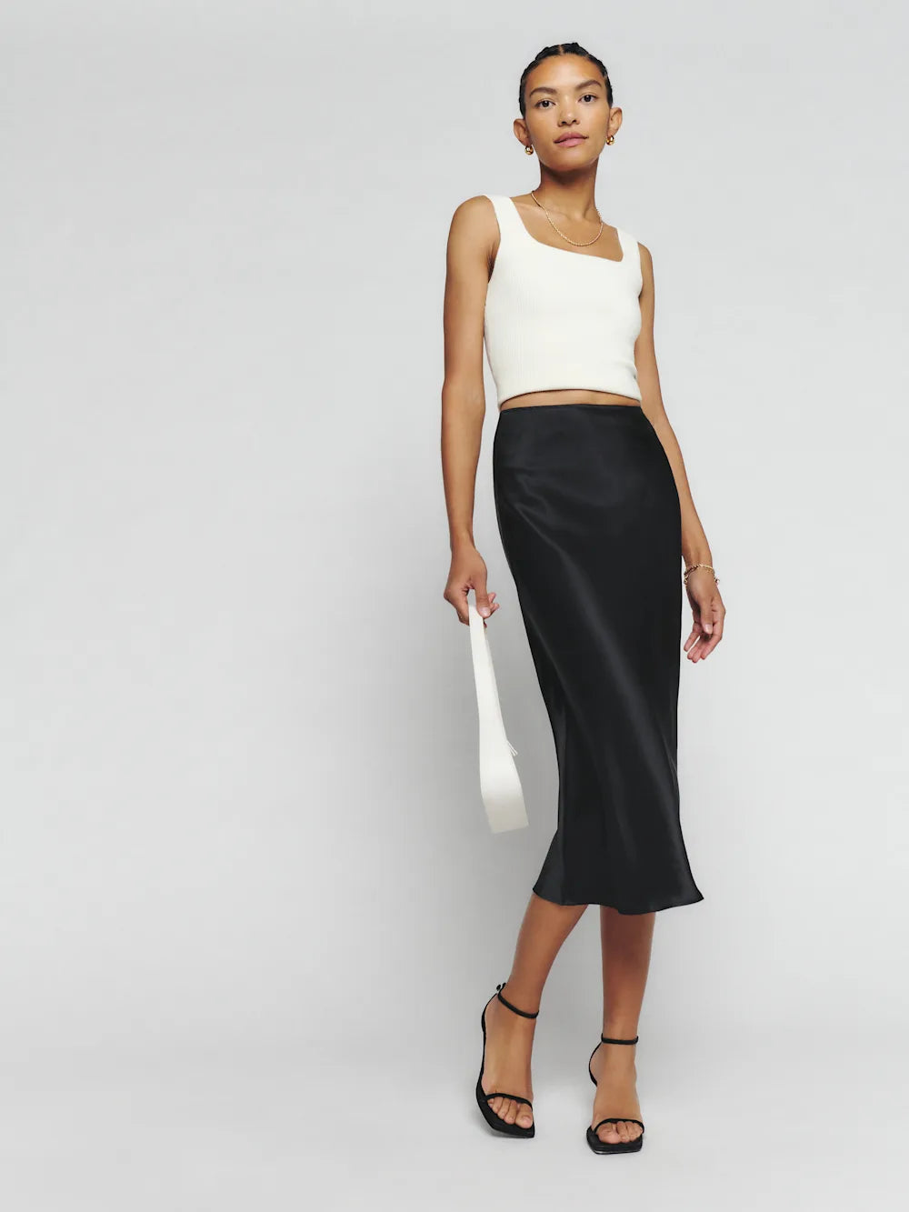 Black silk midi skirt with white crop tank top and black platform sandals — Reformation | Endless UAE