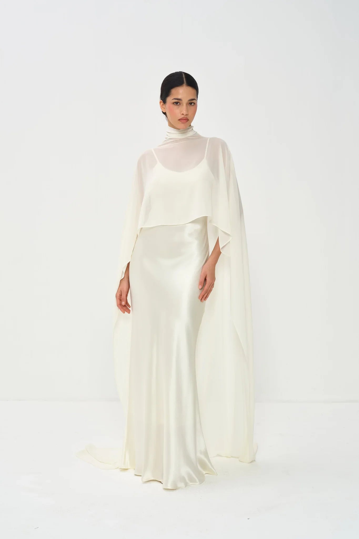 Estelle Cape Maxi Gown in cream with draped cape overlay and turtleneck — Nora The Label | Endless UAE