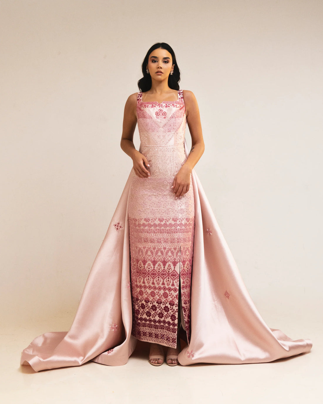 Woman wearing pink embroidered square-neck dress holding thread spools — Reema Dahbour | Endless UAE