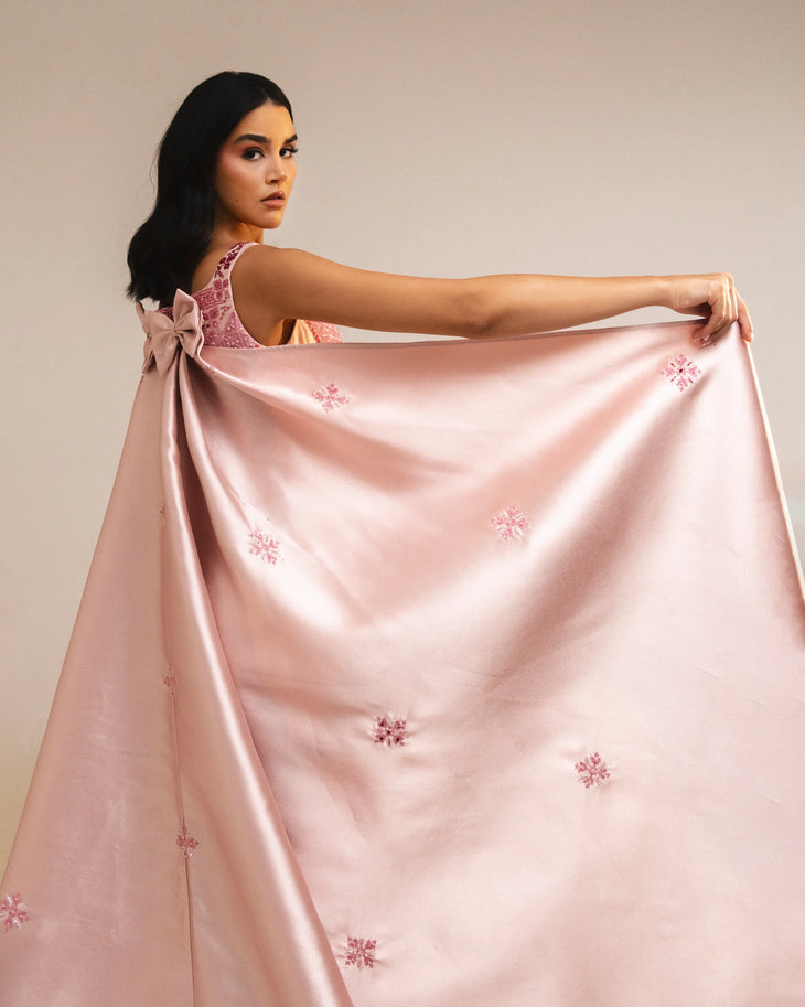 Woman wearing pink embroidered square-neck dress holding thread spools — Reema Dahbour | Endless UAE