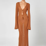 Woman wearing a caramel brown ribbed knit maxi dress with deep V-neckline and tie detail — HYPHEN | Endless UAE