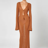 Woman wearing a caramel brown ribbed knit maxi dress with deep V-neckline and tie detail — HYPHEN | Endless UAE