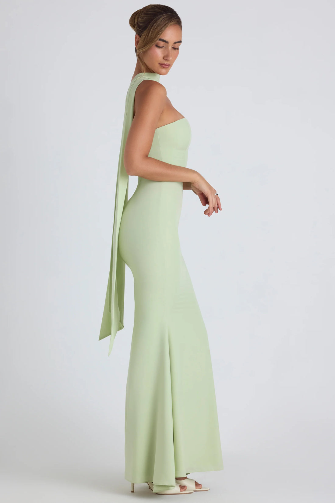 Woman wearing pale green strapless gown with flowing scarf detail — Oh Polly | Endless UAE