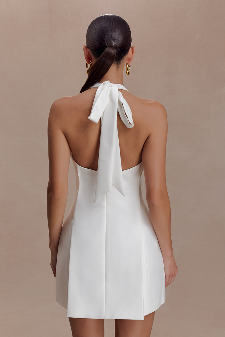 Woman wearing white halter neck cotton mini dress with V-neckline and A-line skirt — Meshki | Endless UAE