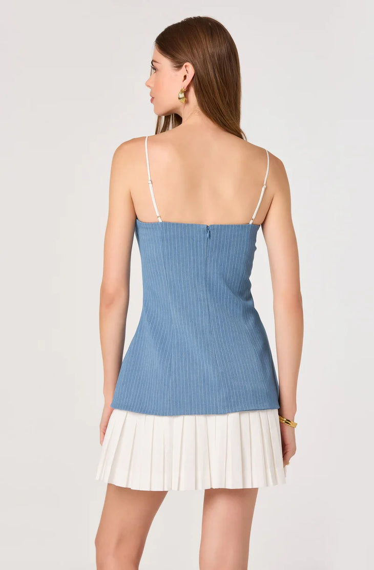 Woman wearing blue pinstriped denim camisole top with white pleated skirt bottom — ASTR the Label | Endless UAE