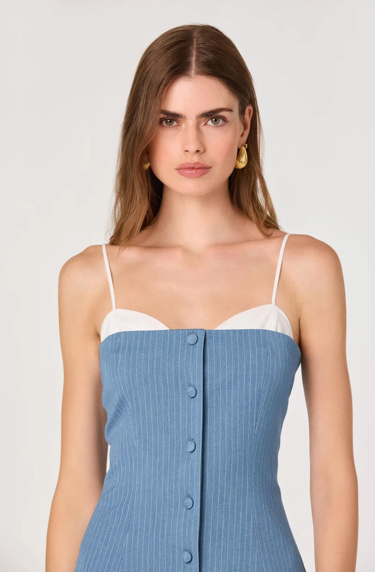 Woman wearing blue pinstriped denim camisole top with white pleated skirt bottom — ASTR the Label | Endless UAE
