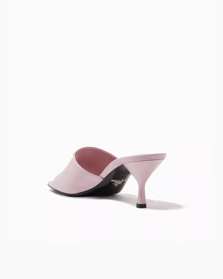Light pink mule heels with triangle logo detail worn with black midi skirt — Prada | Endless UAE