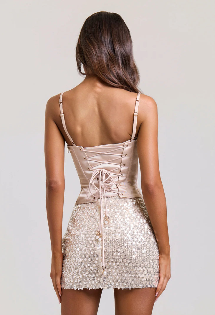 Woman wearing beige corset top with sequined mini skirt against neutral background — Sydney Lane | Endless UAE