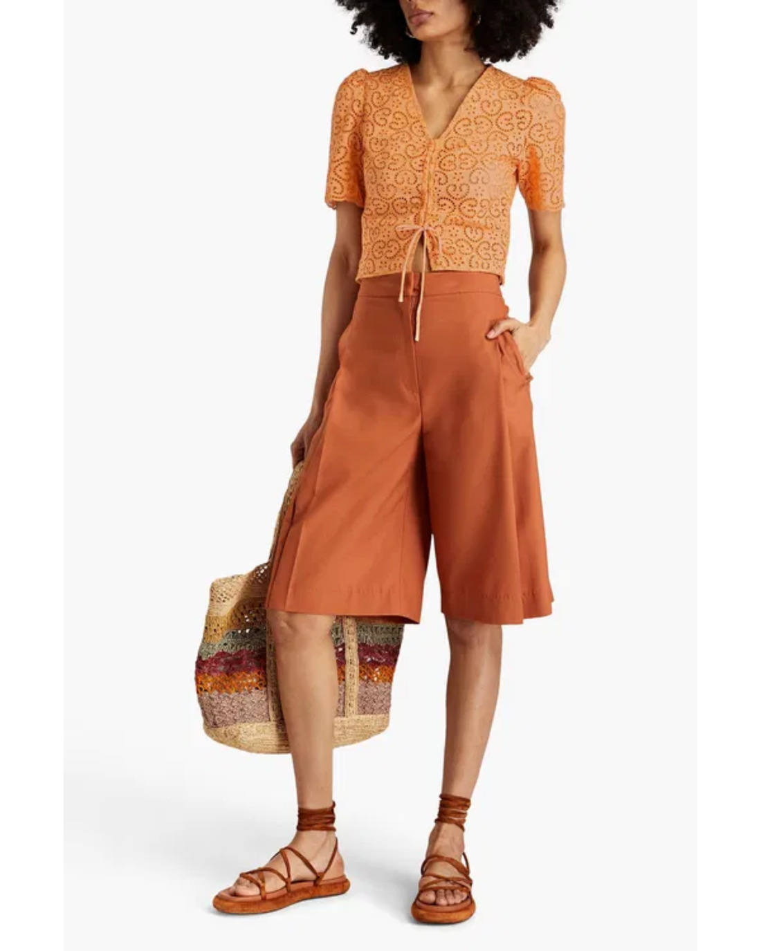 Woman wearing orange broderie anglaise top with matching culottes and woven bag — Sandro | Endless UAE