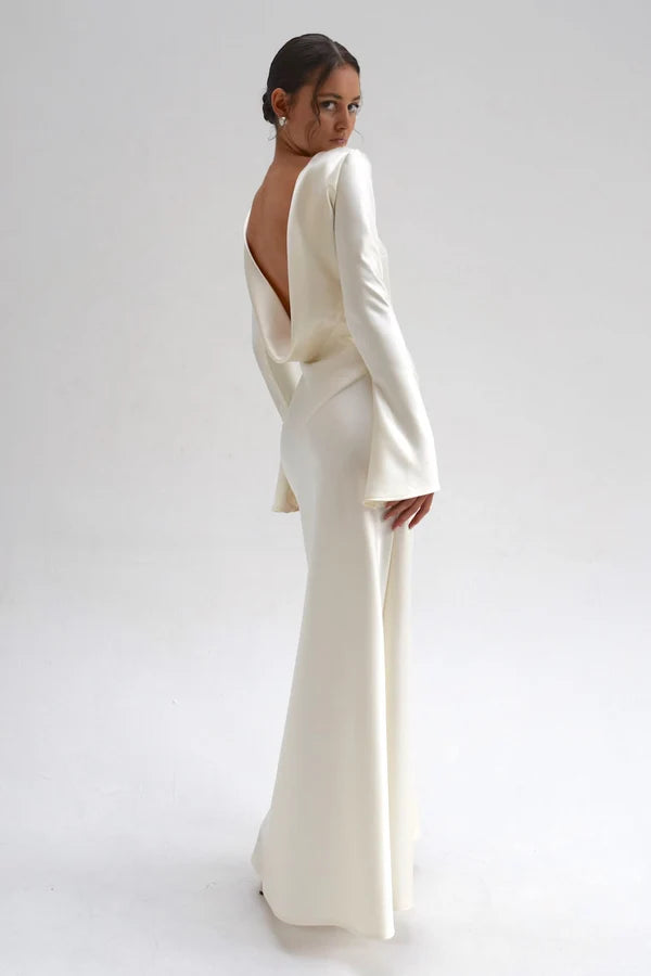 Bride in white satin Eden Dress holding white flowers — One Addington | Endless UAE