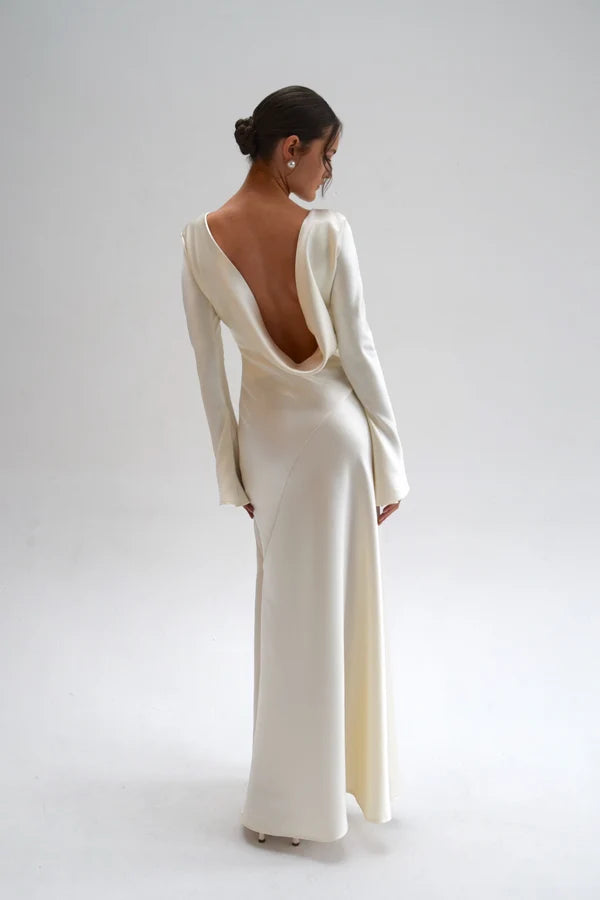 Bride in white satin Eden Dress holding white flowers — One Addington | Endless UAE