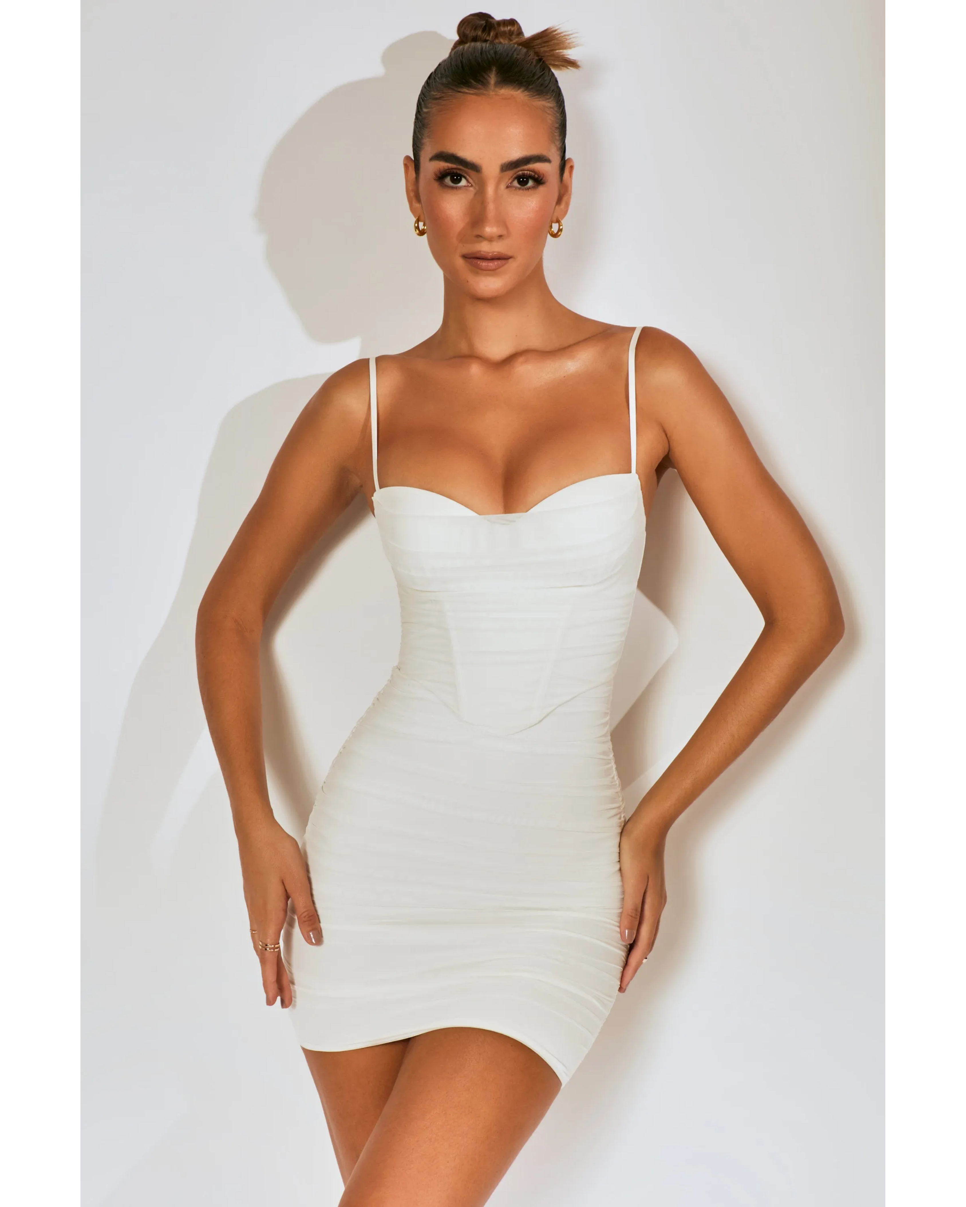 Woman wearing white ruched corset mini dress with spaghetti straps — Oh Polly | Endless UAE