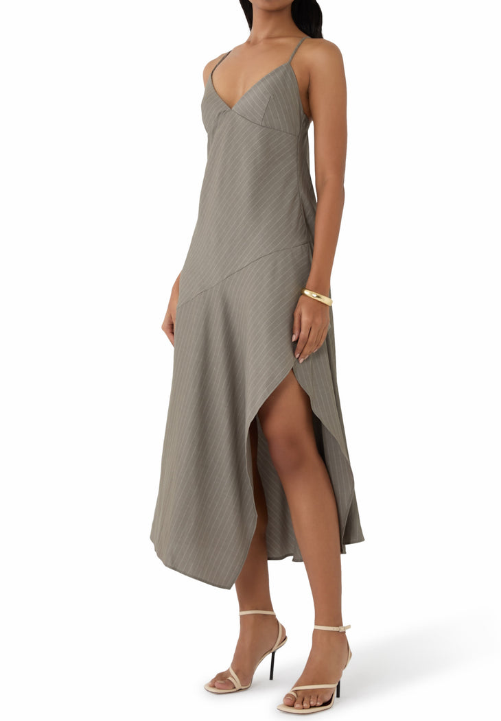 Woman wearing grey pinstriped asymmetric slip dress with thin straps and high slit — St Agni | Endless UAE