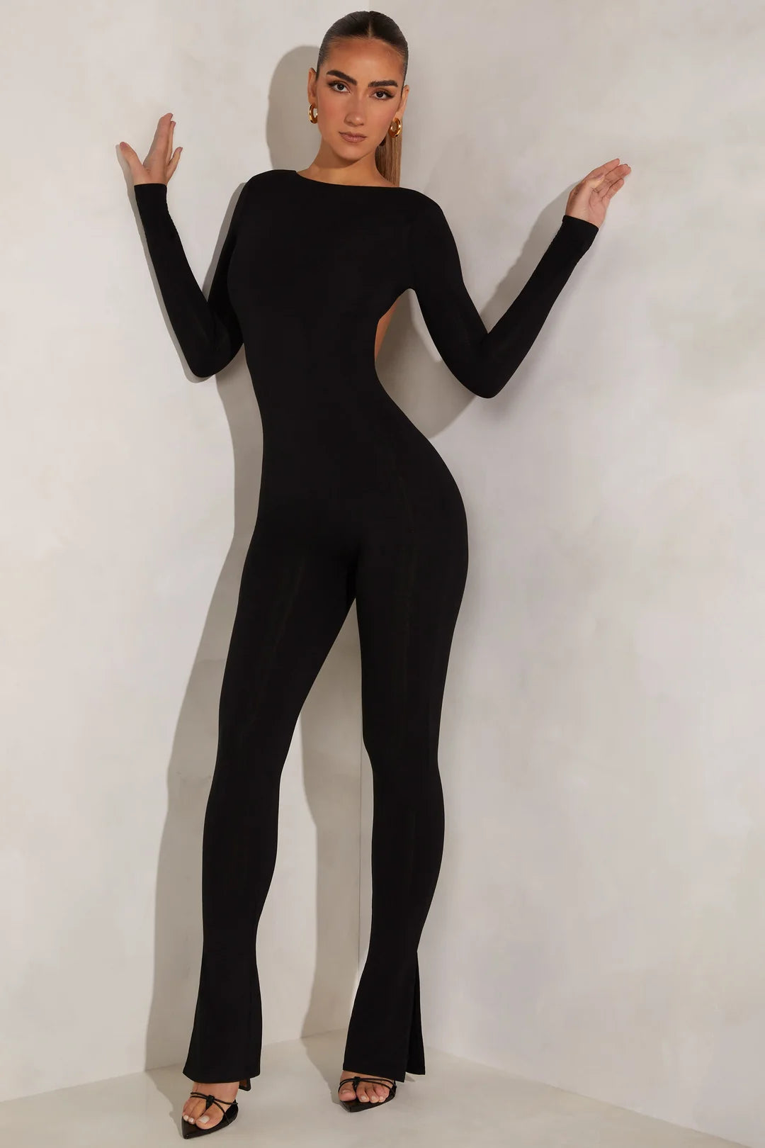 Woman wearing black long-sleeve high neck open back jumpsuit with flared legs — Oh Polly | Endless UAE