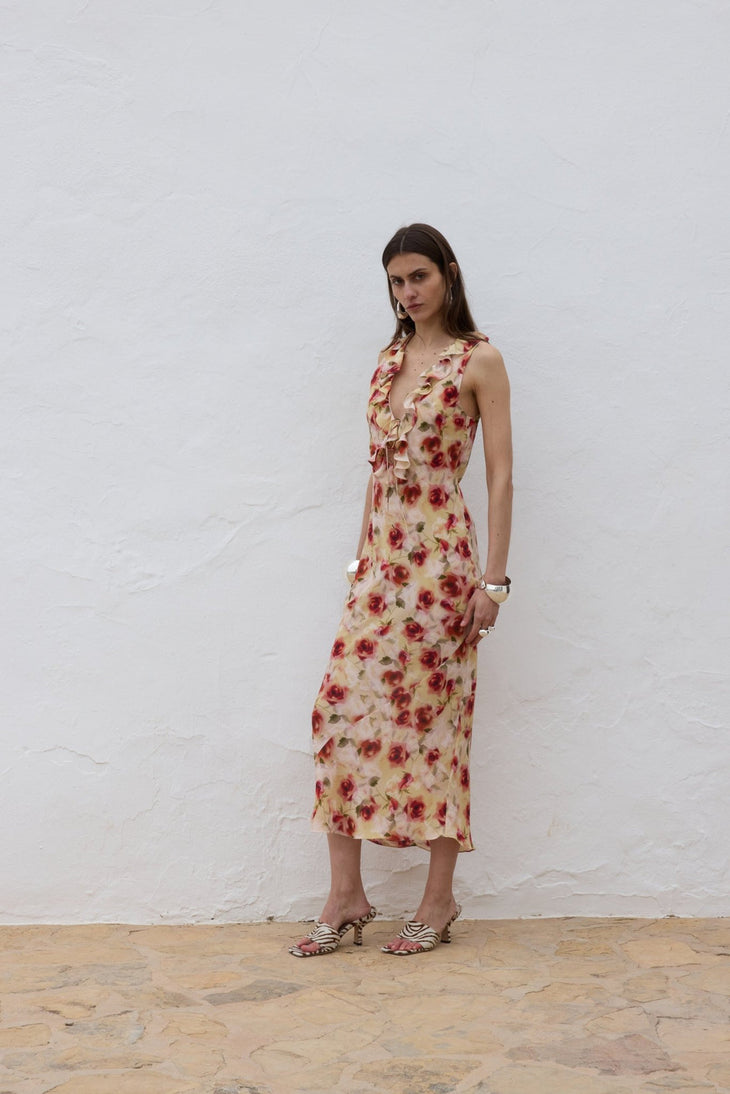Woman wearing red floral midi dress against white wall — De La Vali | Endless UAE
