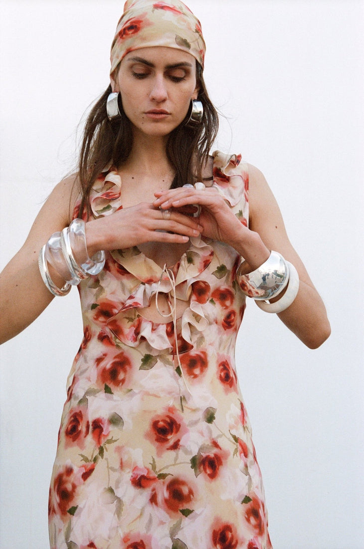 Woman wearing red floral midi dress against white wall — De La Vali | Endless UAE