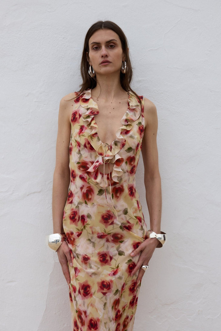 Woman wearing red floral midi dress against white wall — De La Vali | Endless UAE