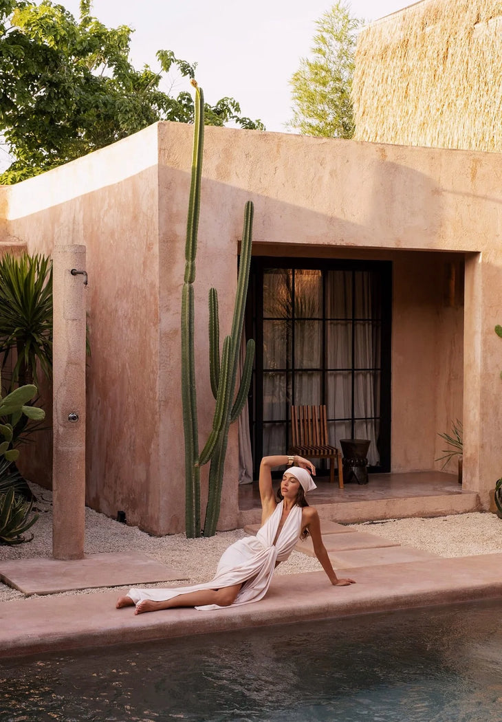 The Amalfi Gown in cream features a plunging halter neckline and draped silhouette — Melissa Phair | Endless UAE