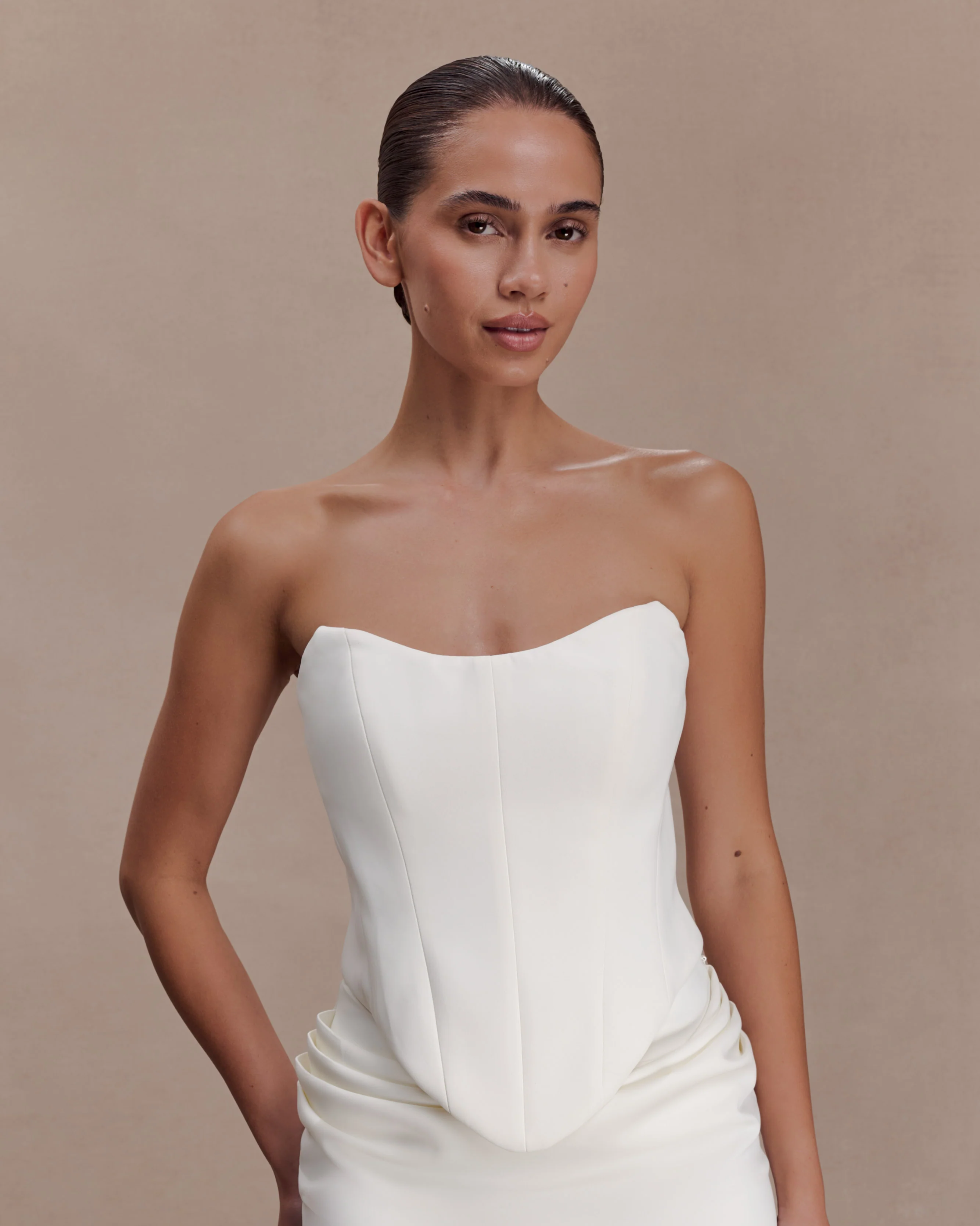 Woman wearing white strapless scuba corset with structured bodice and ruched detail — Meshki | Endless UAE