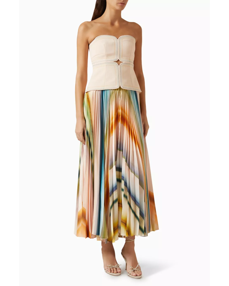 Woman wearing cream strapless top with colorful pleated midi skirt and neutral sandals — Acler | Endless UAE