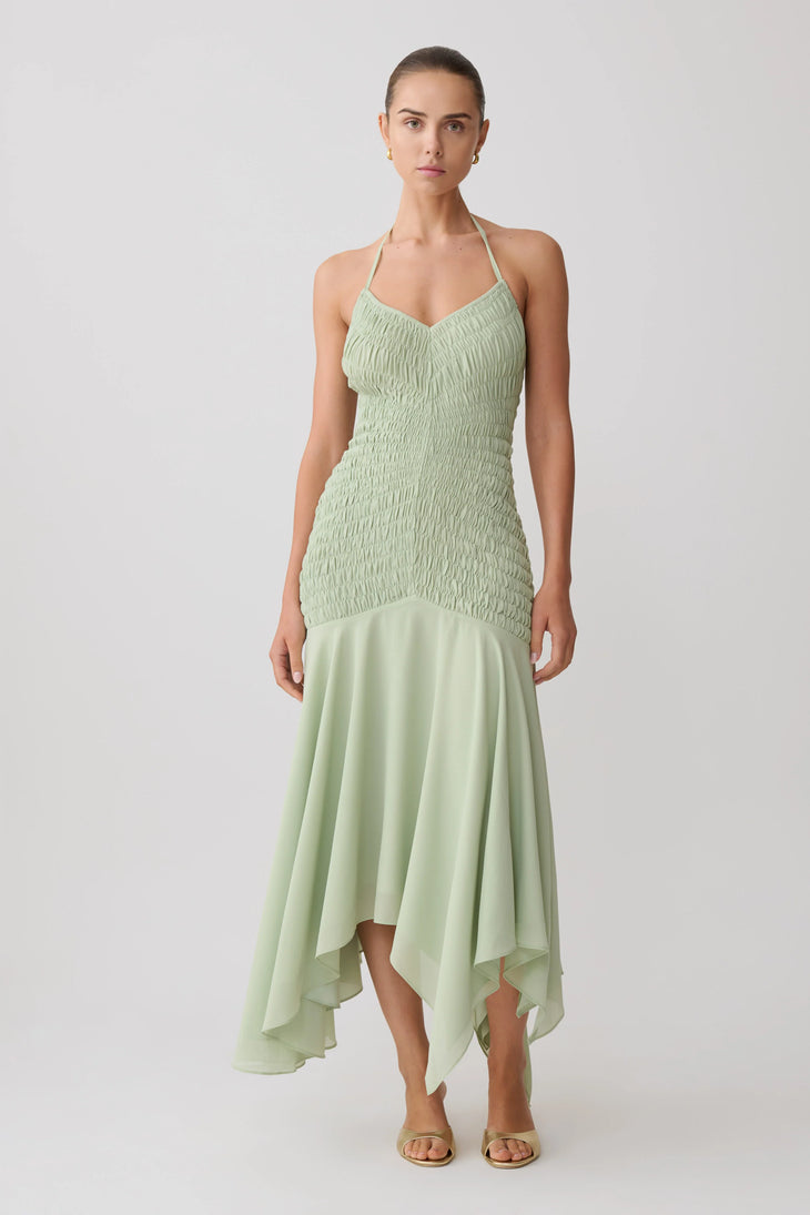 Woman wearing pale green halterneck maxi dress with shirred bodice and asymmetrical hem — Meshki | Endless UAE