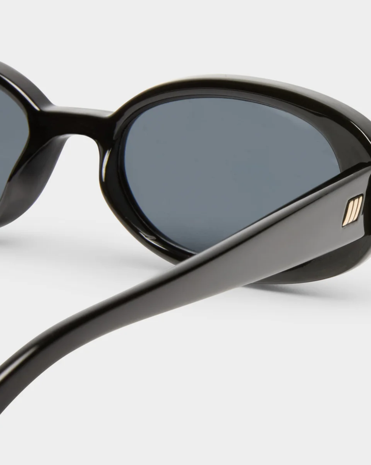 Black oval sunglasses with smoke-tinted lenses and thick frames — Le specs | Endless UAE