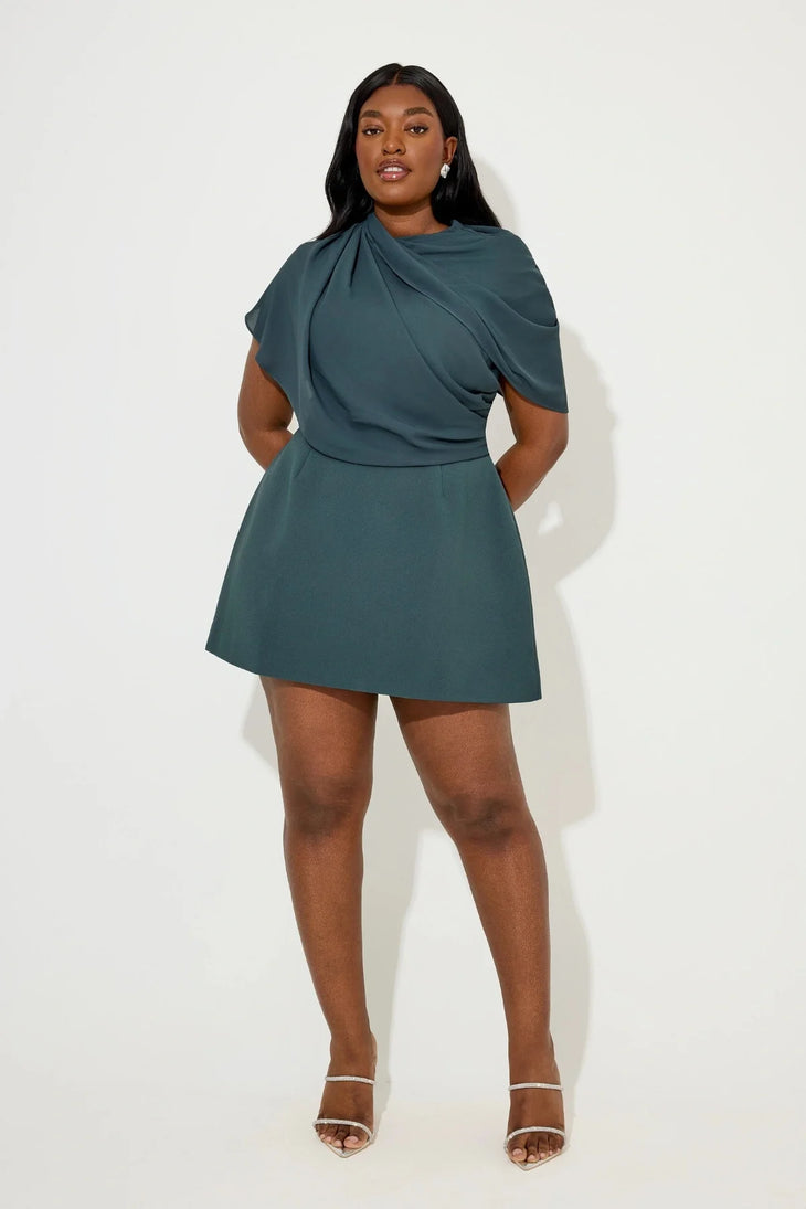 Woman wearing teal gathered mini dress with draped cape detail and white sandals — Aaizel11 | Endless UAE