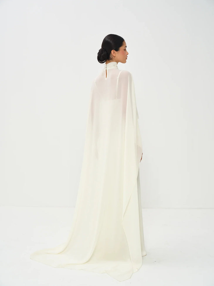 Estelle Cape Maxi Gown in cream with draped cape overlay and turtleneck — Nora The Label | Endless UAE