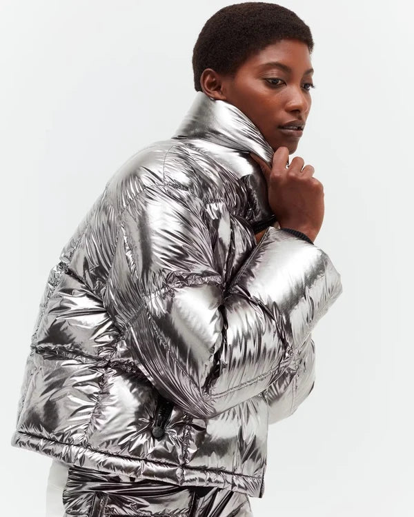 Model wearing metallic silver puffer jacket and matching pants against white background — Perfect moment | Endless UAE