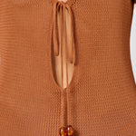 Woman wearing a caramel brown ribbed knit maxi dress with deep V-neckline and tie detail — HYPHEN | Endless UAE