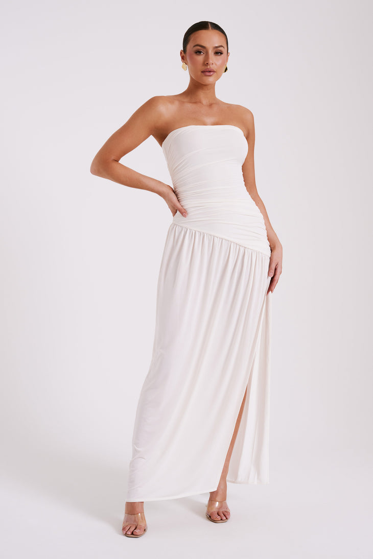 Woman wearing a white strapless ruched maxi dress with asymmetrical hem — Meshki | Endless UAE
