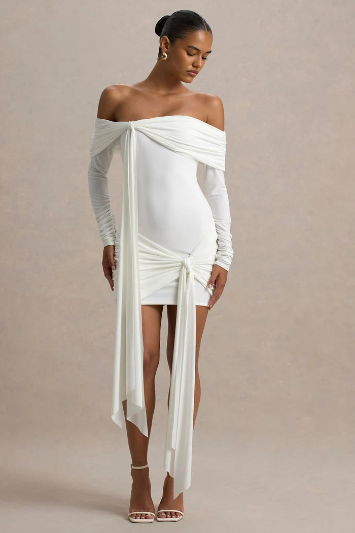 Woman wearing white Bardot wrap mini dress with off-shoulder design and long sleeves — Club L London | Endless UAE
