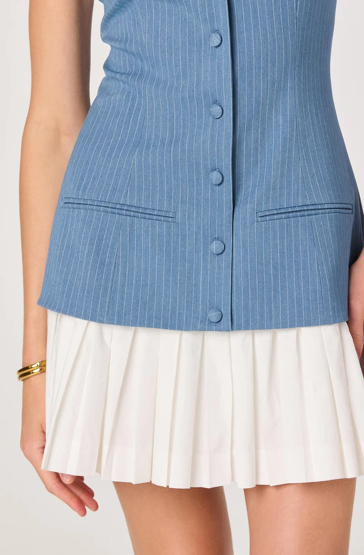 Woman wearing blue pinstriped denim camisole top with white pleated skirt bottom — ASTR the Label | Endless UAE