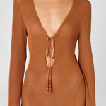 Woman wearing a caramel brown ribbed knit maxi dress with deep V-neckline and tie detail — HYPHEN | Endless UAE