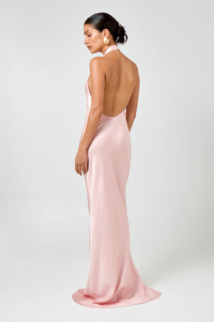 Woman wearing pink Infinity Maxi Dress with halter neckline and gold hoop earrings — Hyphen | Endless UAE