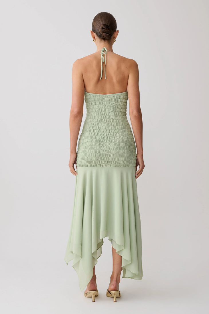 Woman wearing pale green halterneck maxi dress with shirred bodice and asymmetrical hem — Meshki | Endless UAE